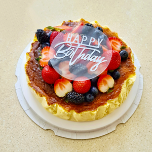 Splatter's homemade basque burnt cheesecake topped with premium mixed berries and a happy birthday acrylic topper