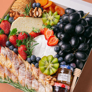 An array of Splatter's Cheese & Fruit Platter ingredients neatly arranged inside a white square box.